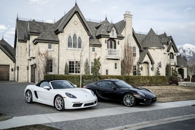 two black and white sports cars parked in front of a house