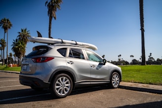A family loading luggage into a spacious SUV in a sunny parking area.
