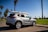 A happy family standing next to their new SUV in a sunny parking lot.