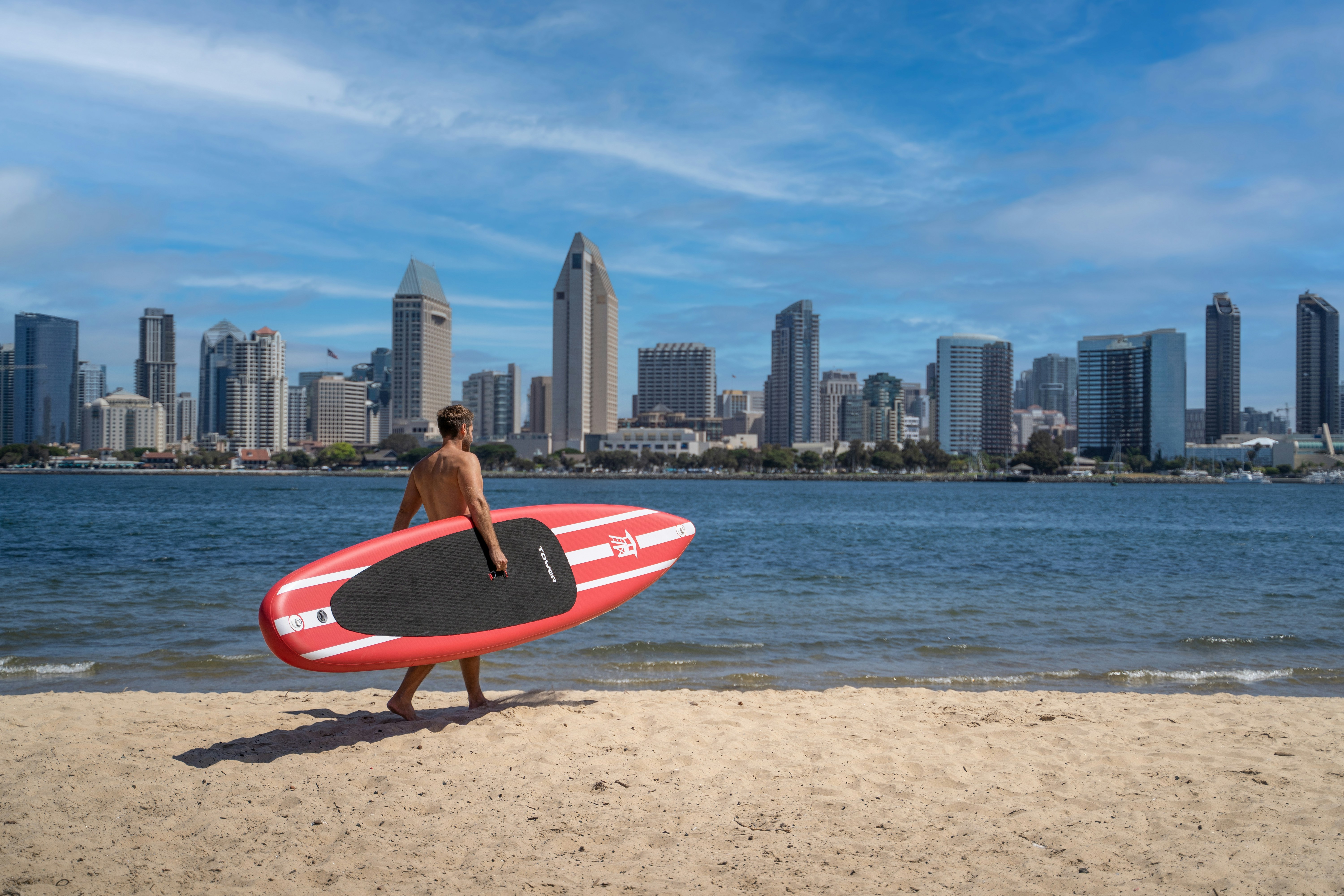 a man holding a surfboard on top of a sandy beach