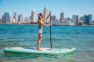 a woman standing on a paddle board in the water
