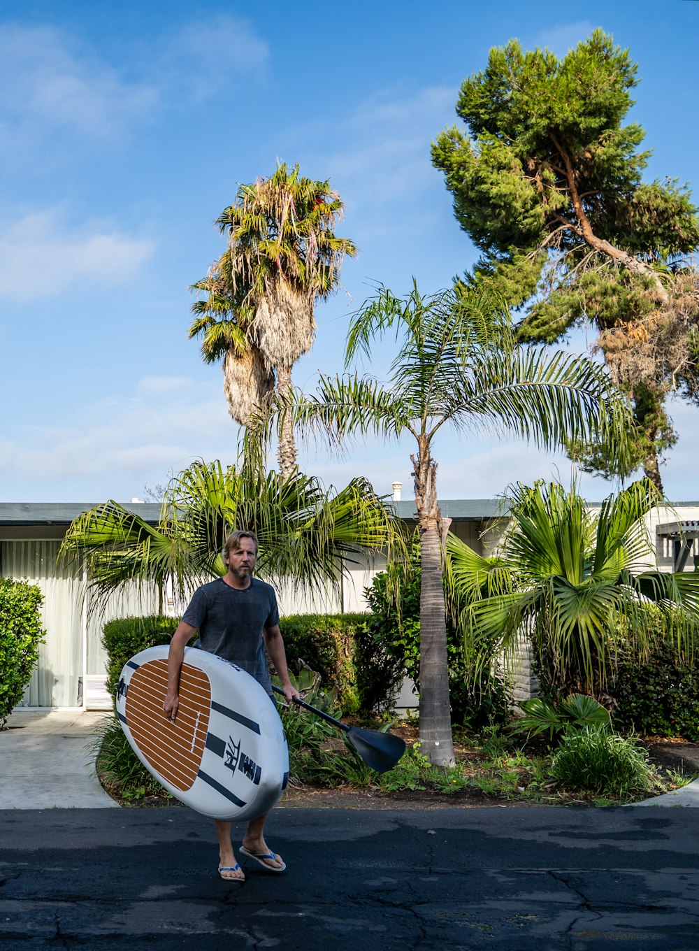 a man holding a surfboard and a paddle