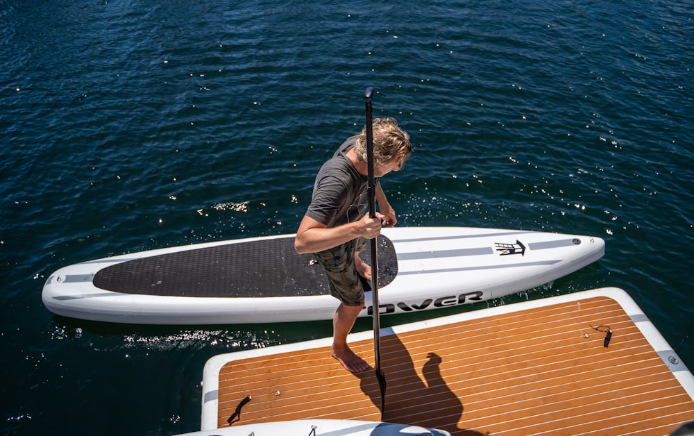 a man standing on a paddle board in the water