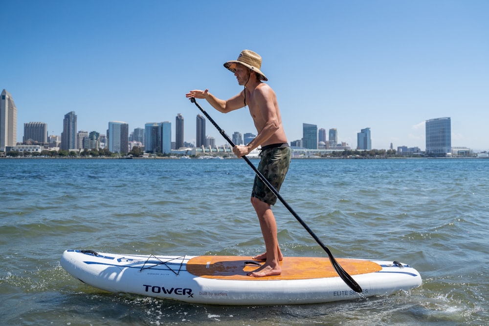 a man standing on a paddle board in the water