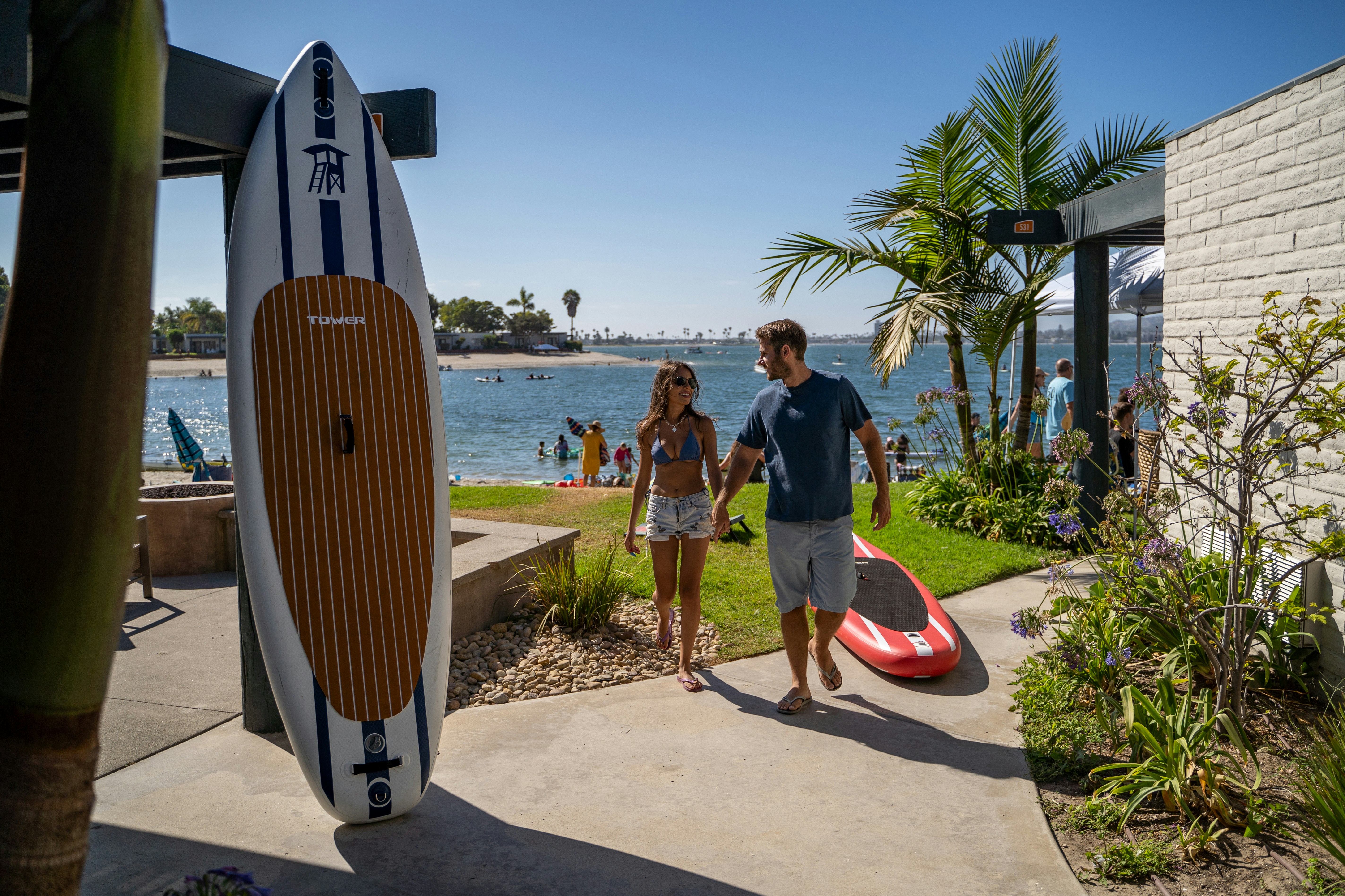a man and a woman standing next to a surfboard