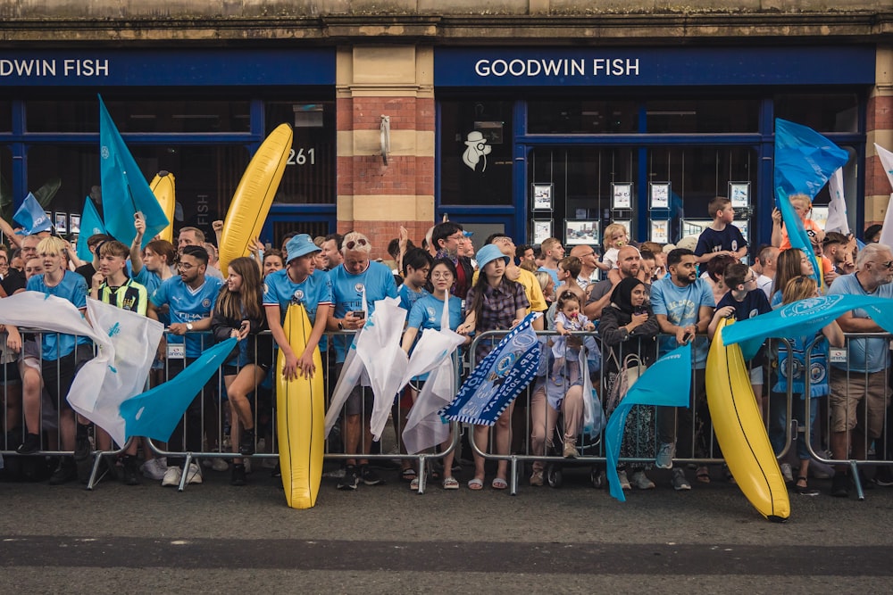 a group of people standing behind a fence