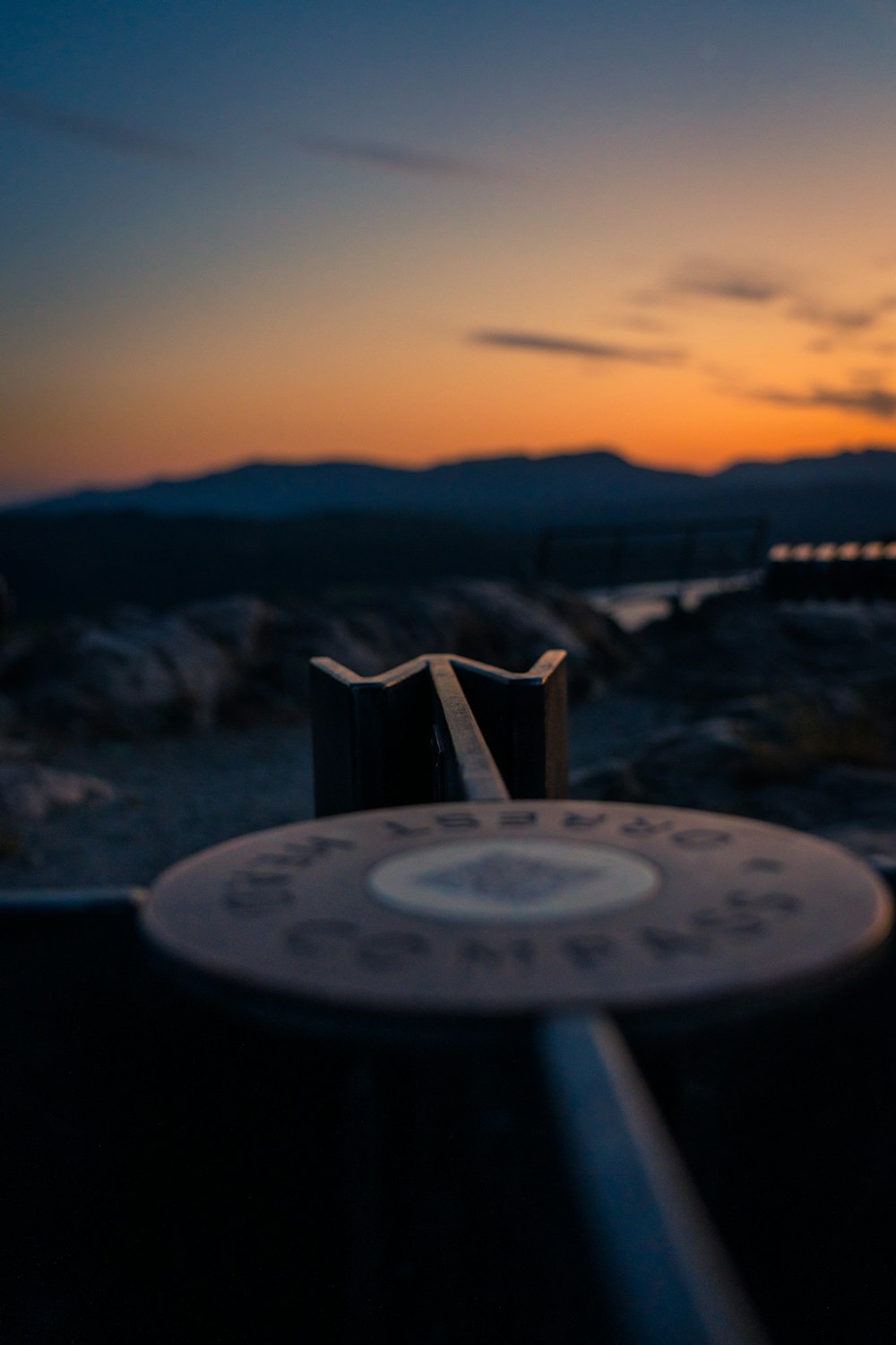 a close up of a metal object with a sunset in the background