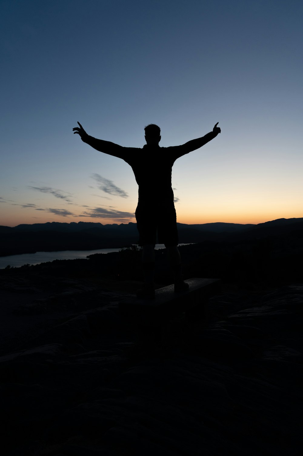 a man standing on top of a hill with his arms outstretched