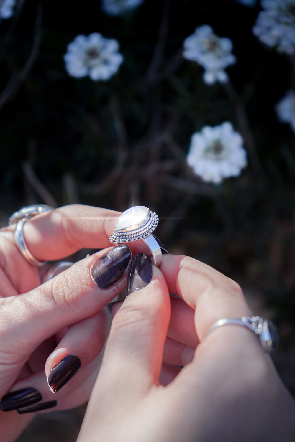 a woman's hands holding a ring in her left hand