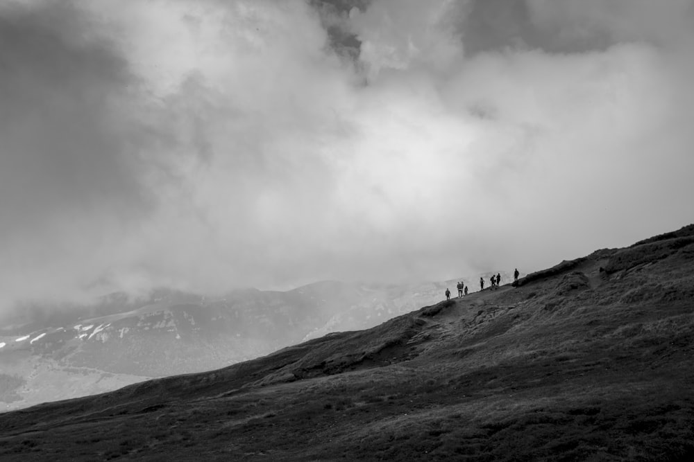 Un groupe de personnes debout au sommet d’une colline verdoyante