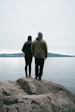 a couple of people standing on top of a rock
