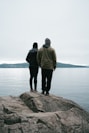 a couple of people standing on top of a rock
