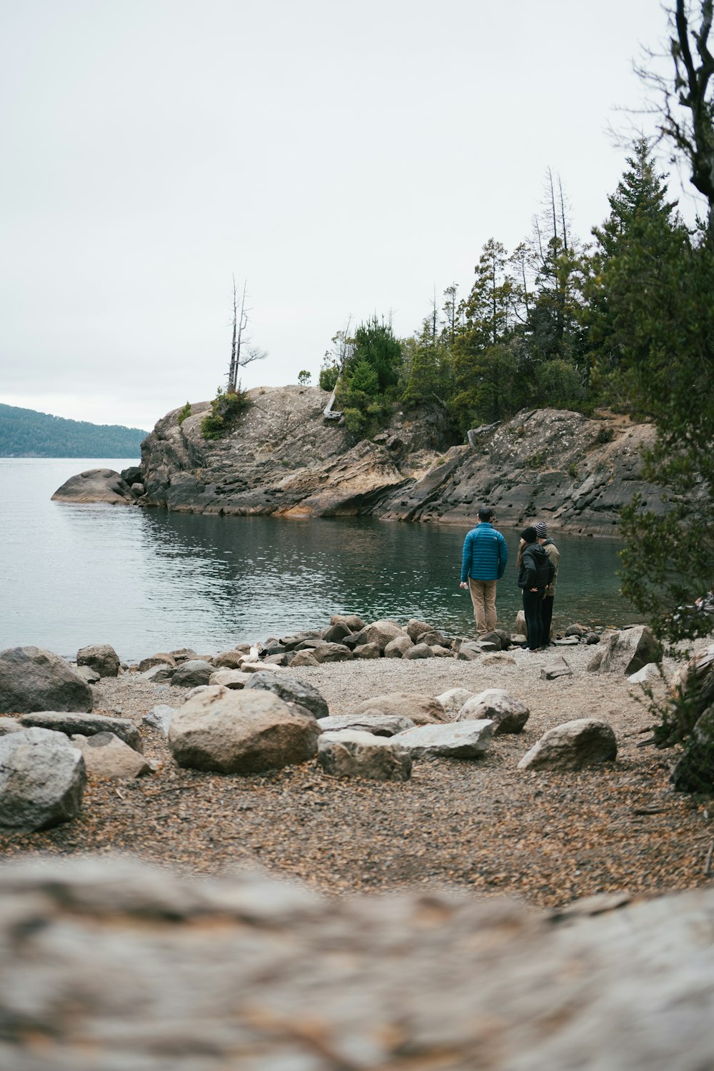 a couple of people standing next to a body of water