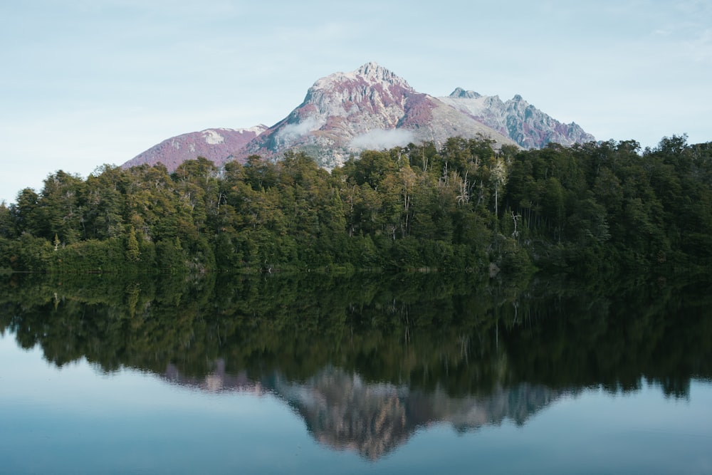 a mountain is reflected in the still water of a lake