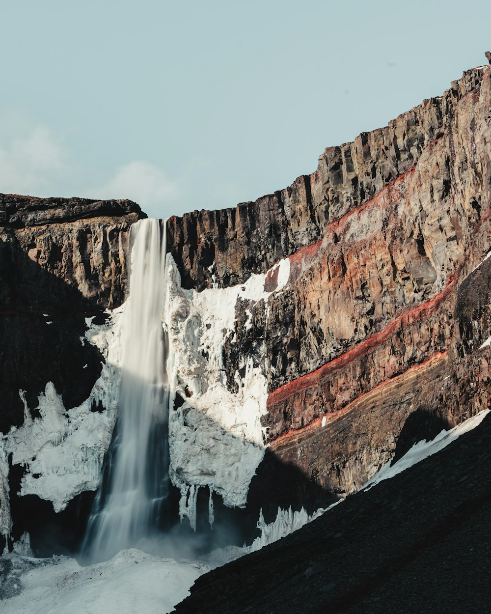 a large waterfall in the middle of a mountain