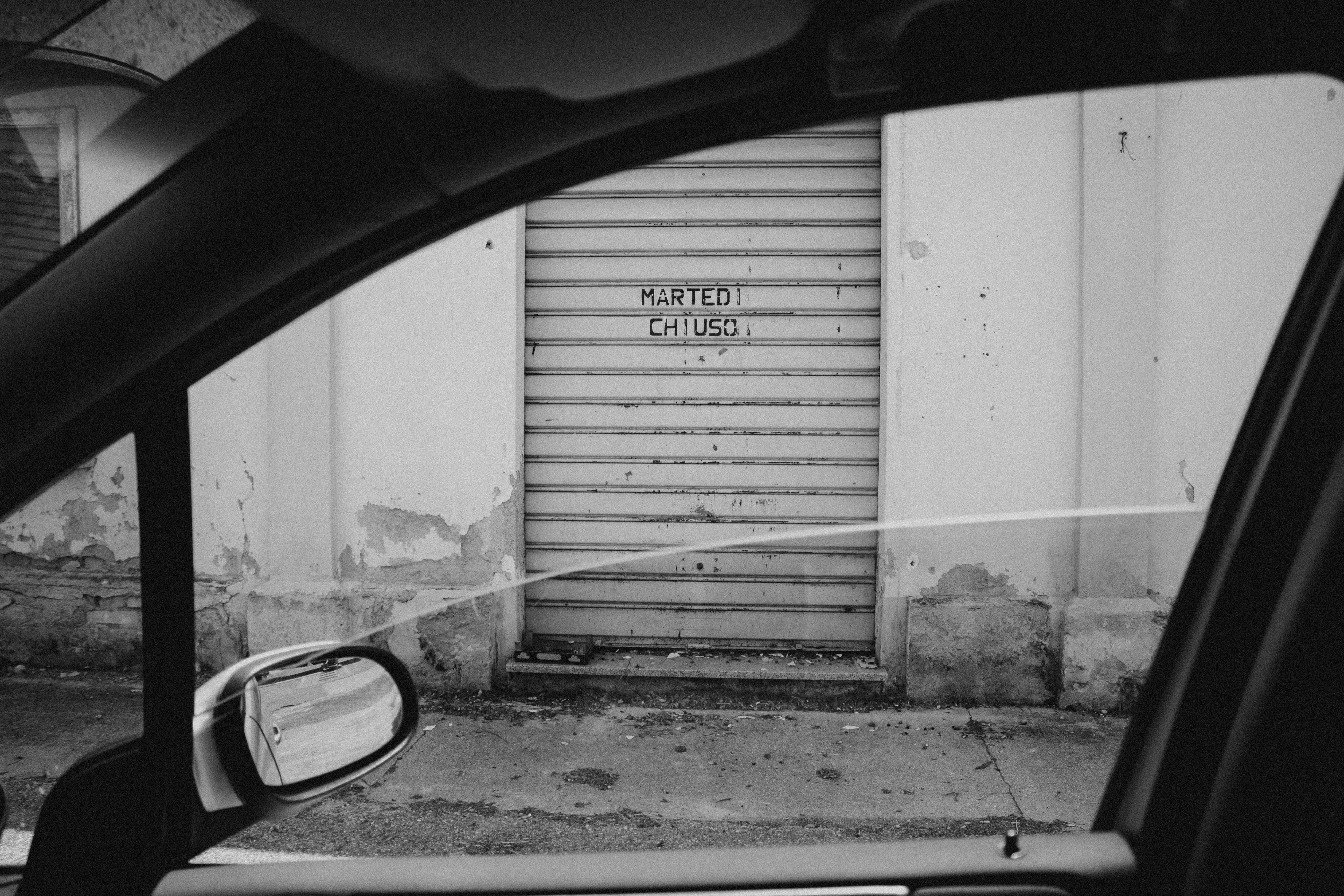 a black and white photo of a door and a car
