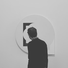 a man standing in front of a white wall