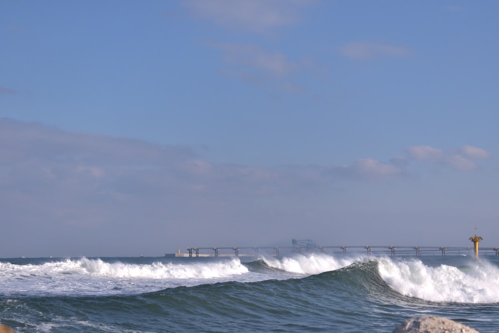 a large body of water with a bridge in the background