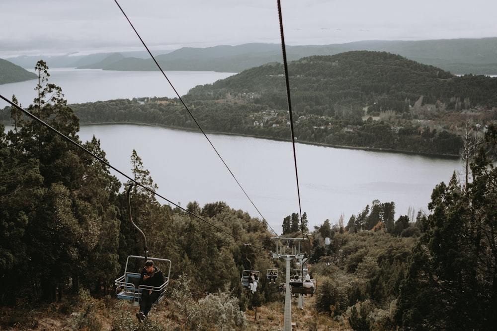 a person riding a ski lift over a lake