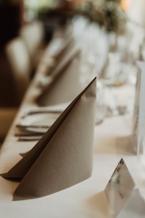 Elegant restaurant napkins and tablecloths freshly pressed and arranged on a wooden table.