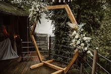 a wooden frame decorated with flowers and greenery