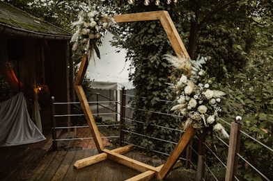 a wooden frame decorated with flowers and greenery