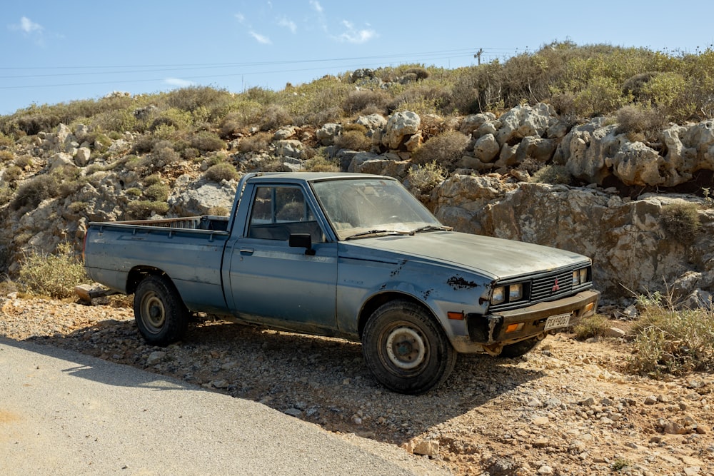 a blue pick up truck parked on the side of a road
