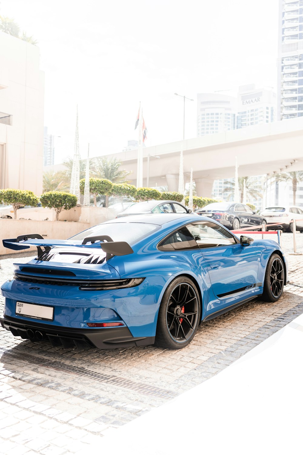 a blue sports car parked in front of a building