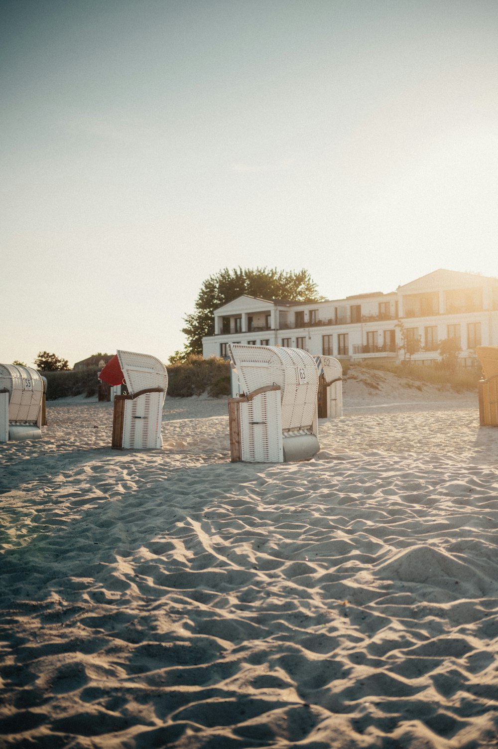 a row of beach chairs sitting on top of a sandy beach