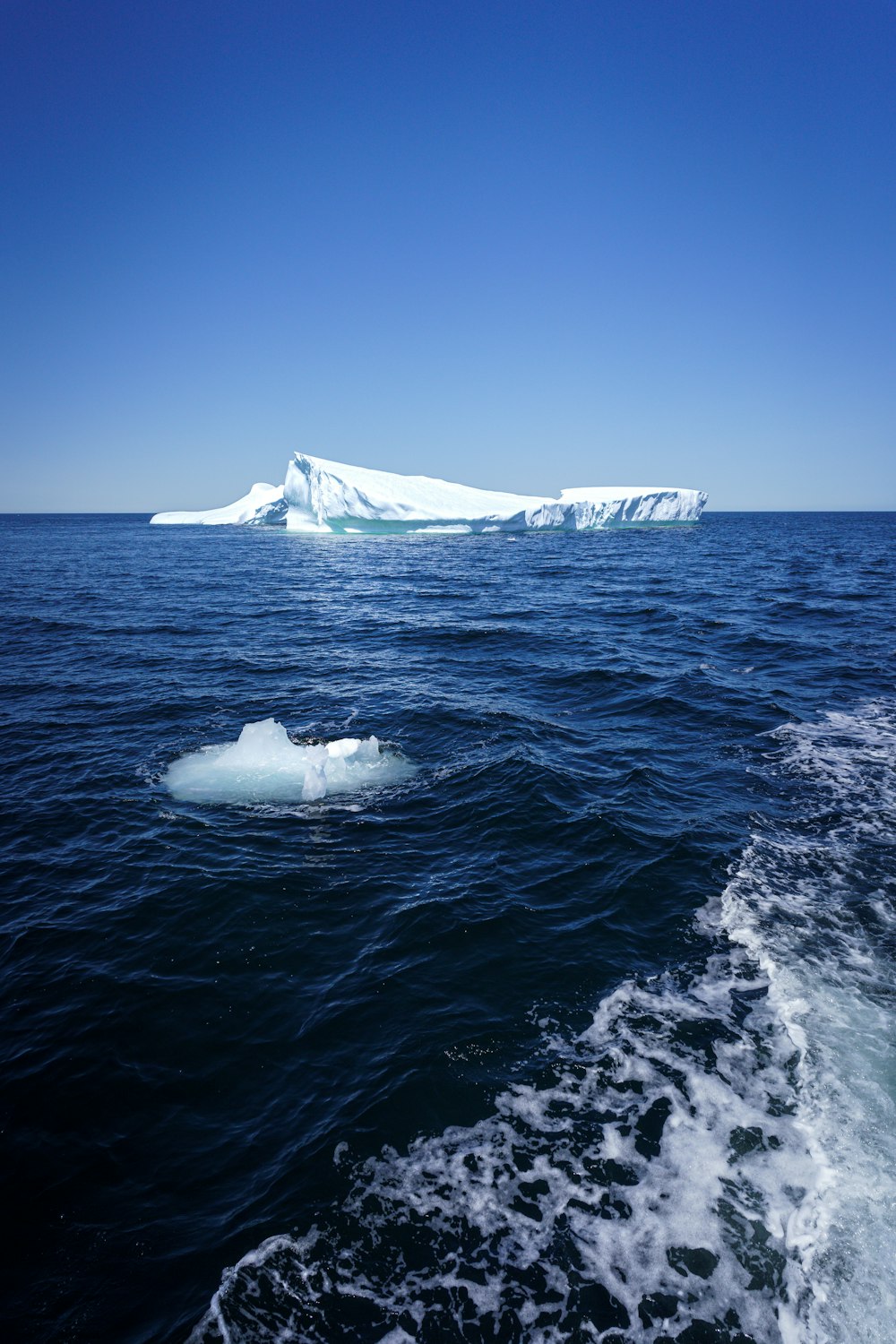 an iceberg floating in the middle of the ocean