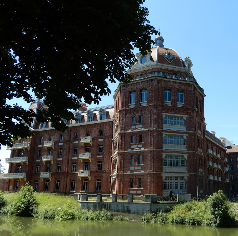 a large red brick building sitting next to a body of water