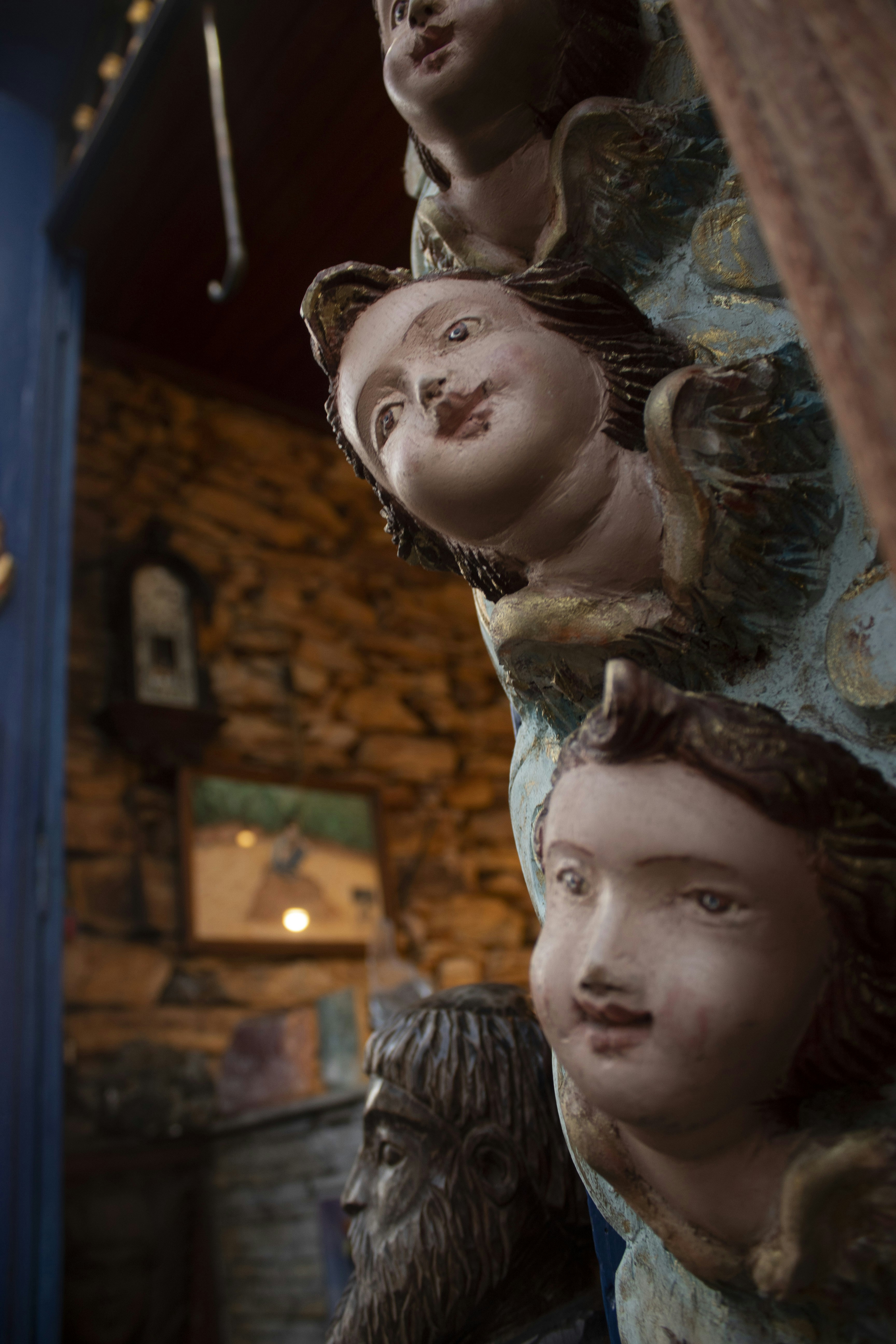 a group of statues of people hanging from a ceiling