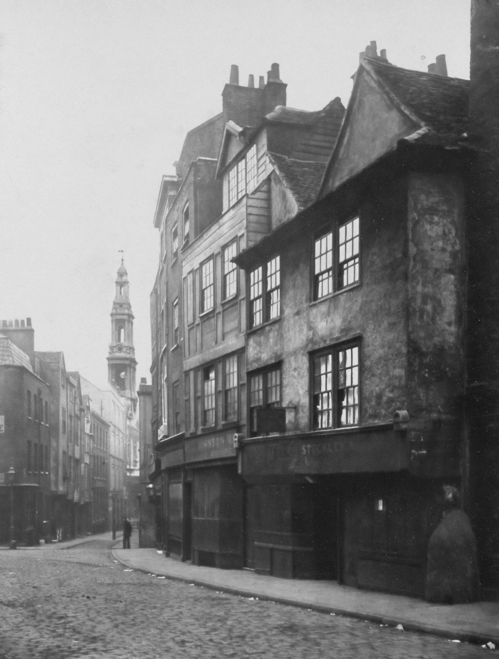 an old black and white photo of a cobblestone street