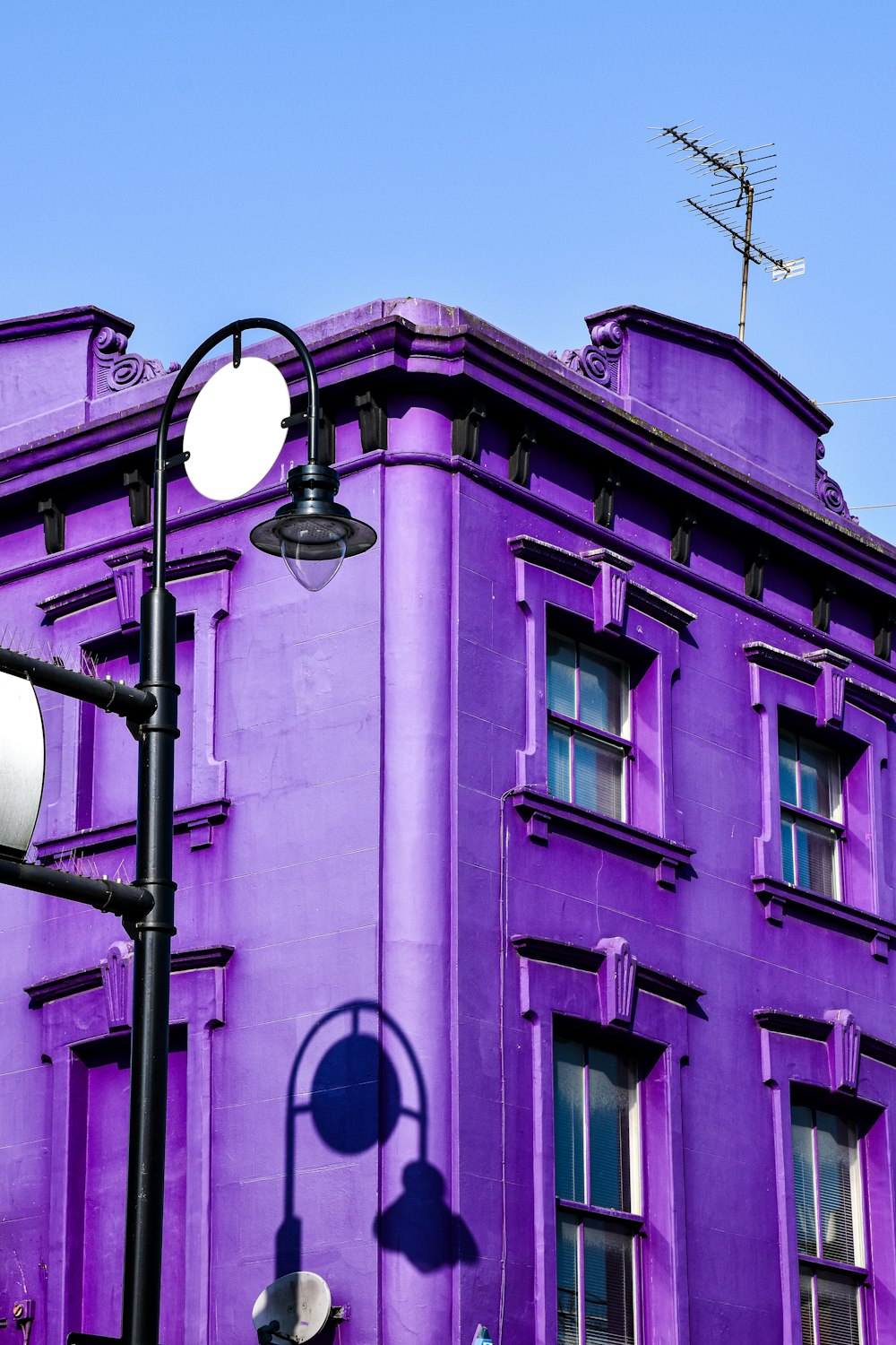 a tall purple building sitting next to a traffic light