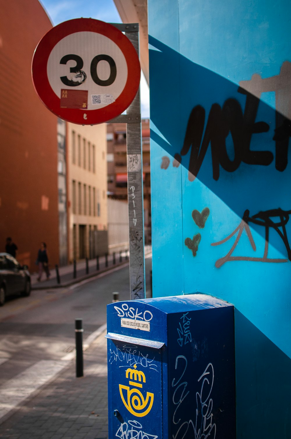 a blue mailbox sitting next to a blue wall