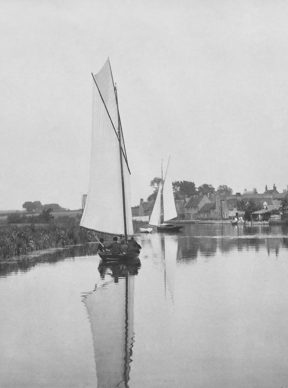 a black and white photo of a sailboat on the water