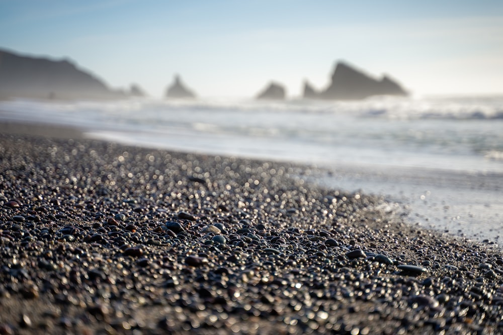 a close up of rocks on a beach near the ocean