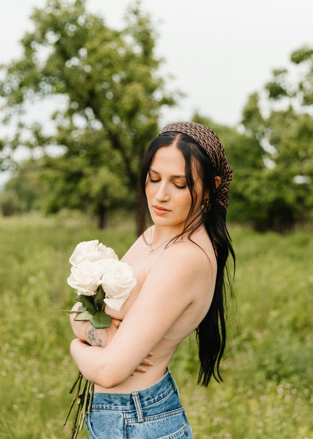 a woman holding a bouquet of flowers in a field