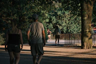 A panoramic shot of a serene park with jogging paths and families relaxing under shady trees.