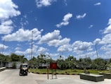 Electric tricycles parked near farmland under a clear sky.