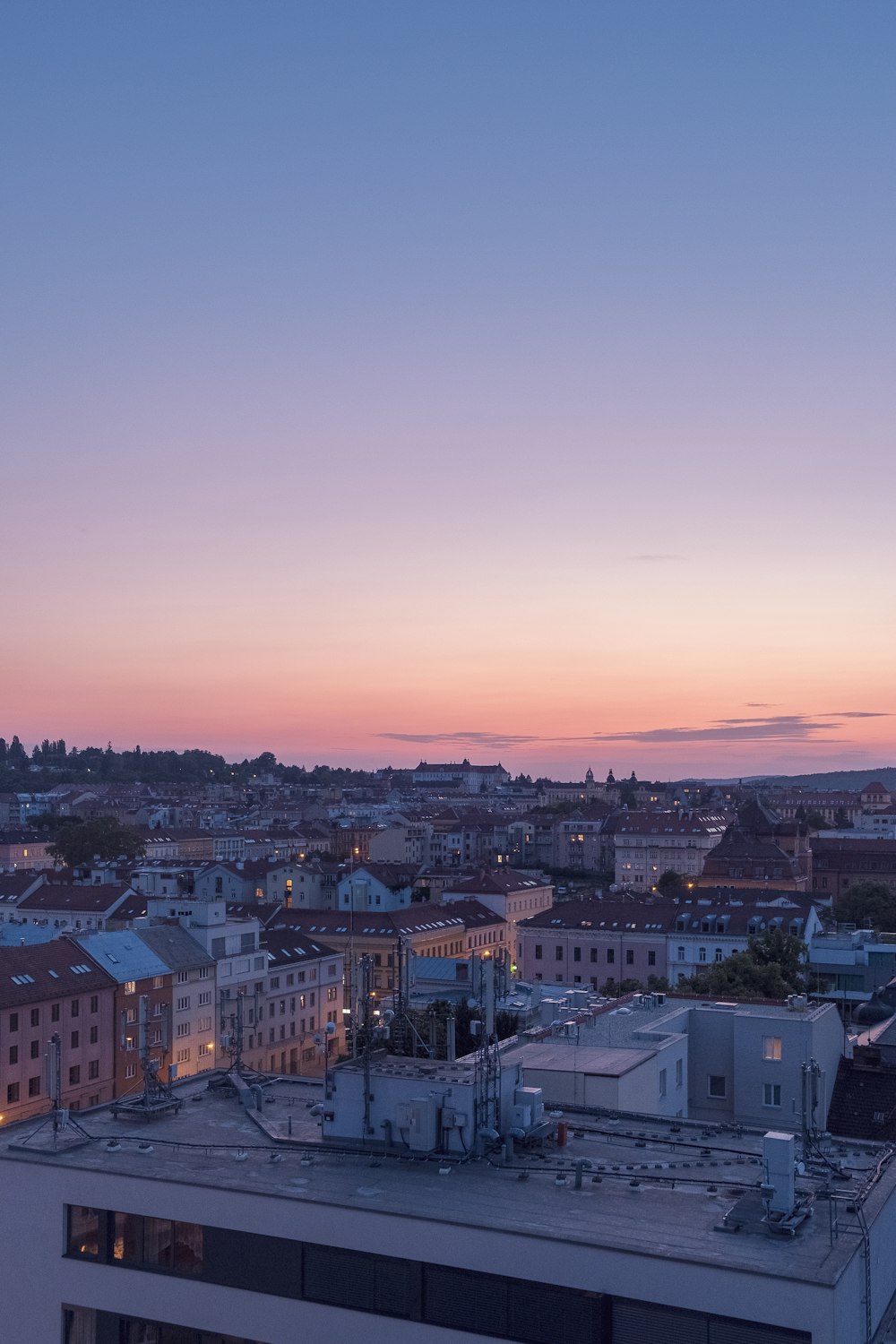 a view of a city at dusk from a rooftop