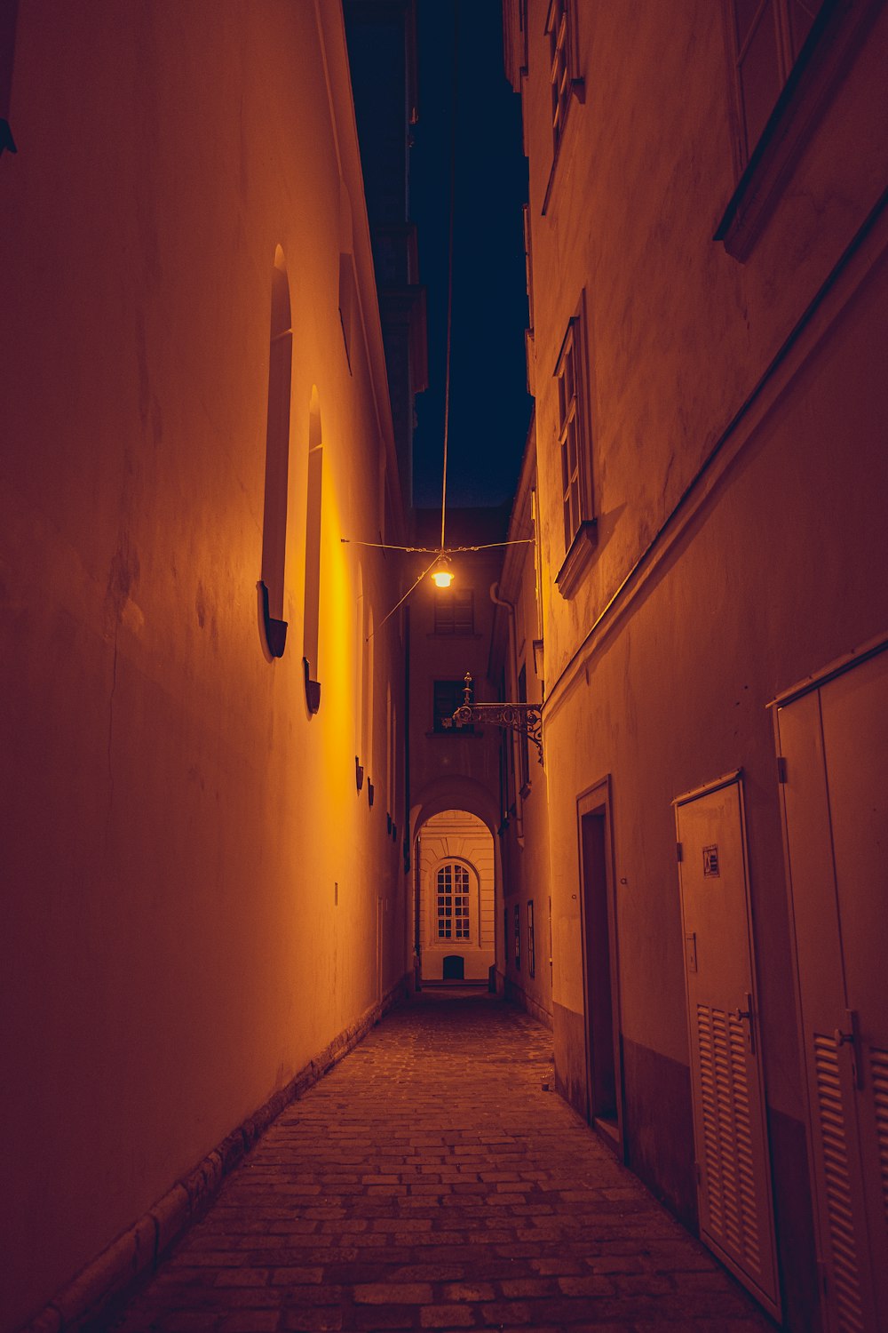 a narrow alley way with a clock on the wall