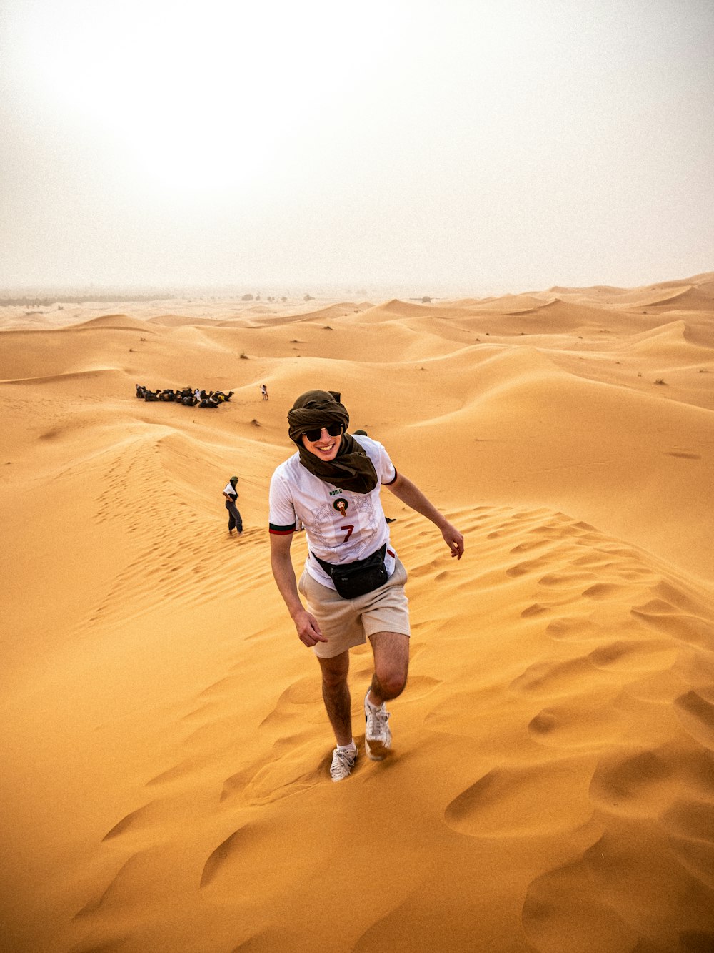 a man walking across a sandy field