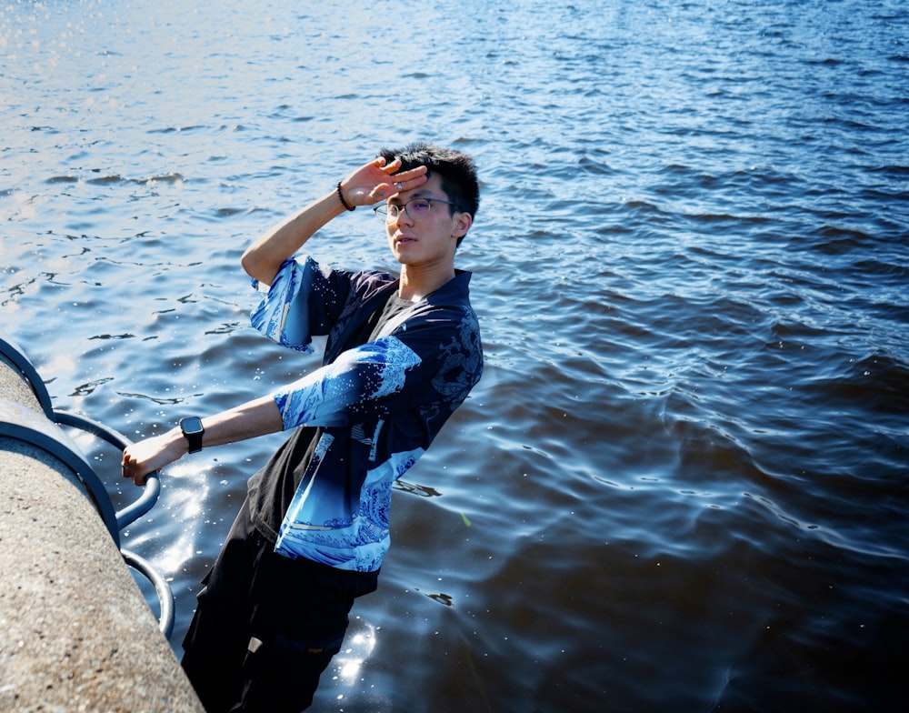 a man standing in the water with his hand on his head