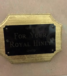 A charming construction sign with a royal crown emblem against a soft pastel background.