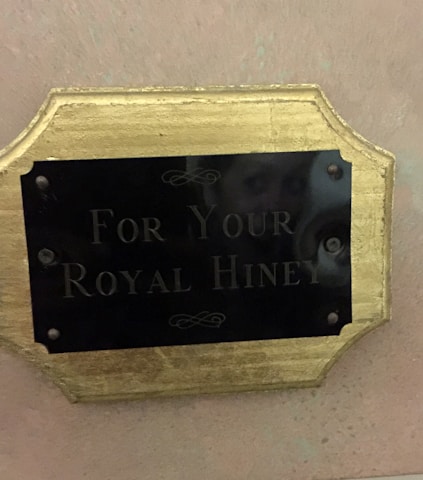 A charming construction sign with a royal crown emblem against a soft pastel background.