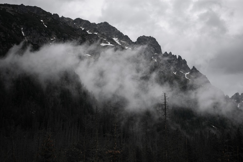 a mountain covered in fog and clouds on a cloudy day