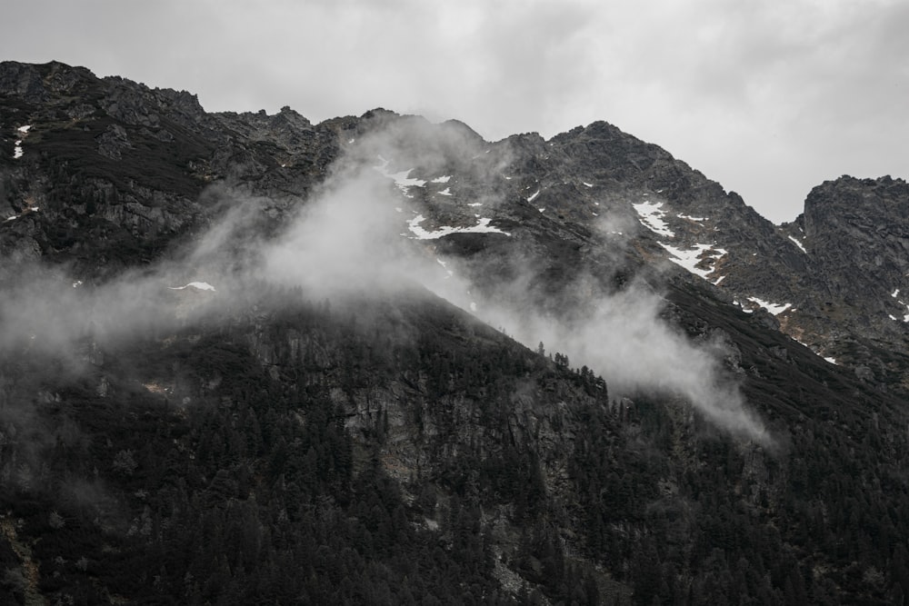 a mountain covered in fog and clouds on a cloudy day