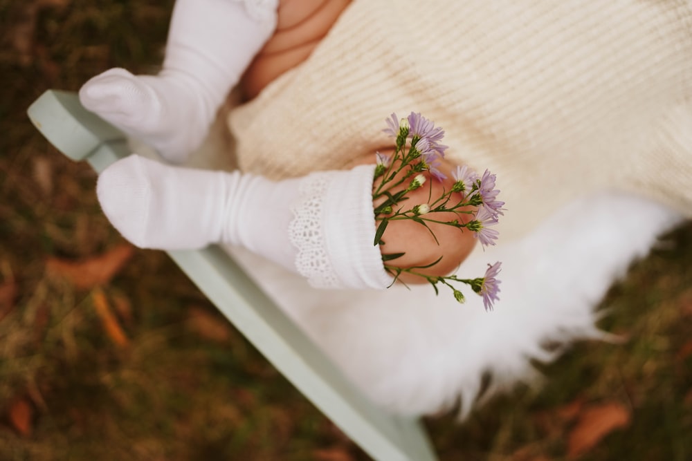 a baby's hand holding a bunch of flowers
