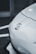 A close-up view of the front of a white automobile featuring the Toyota logo prominently displayed on the hood. The image captures the sleek and smooth lines of the vehicle against a blurred background.